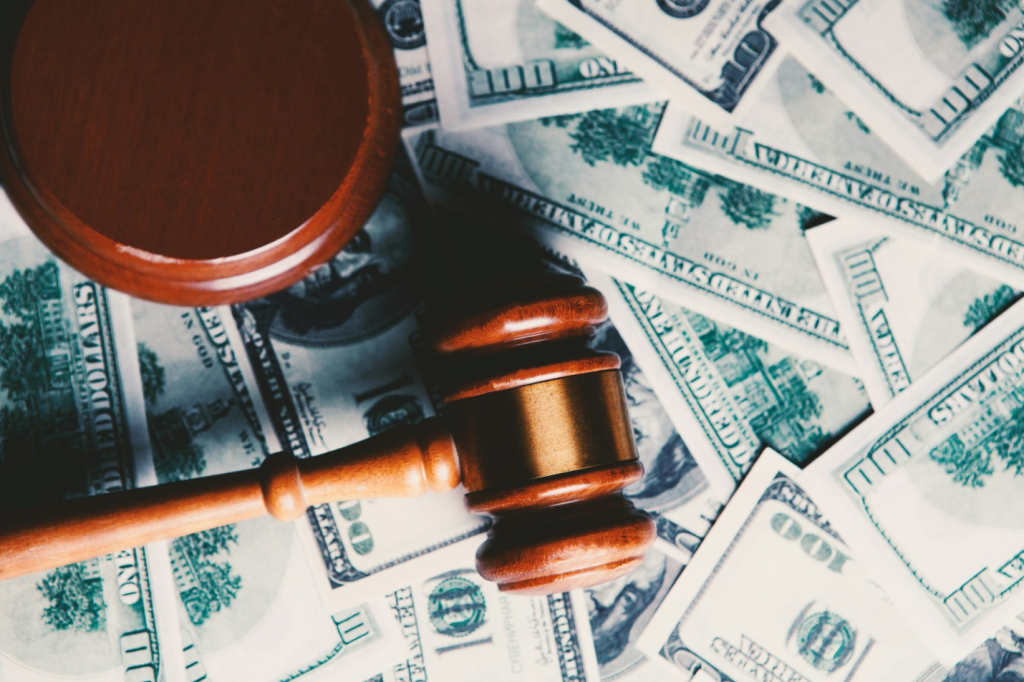 A wooden gavel placed on 100 US dollar banknotes