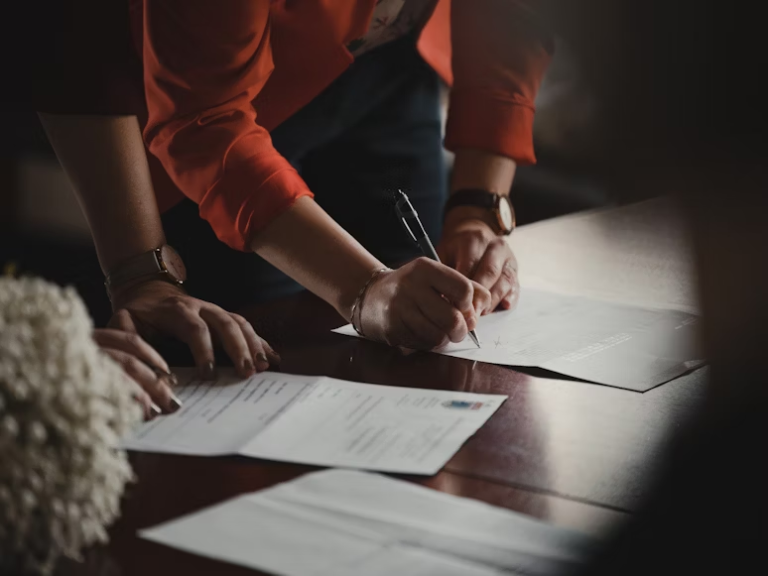 a person in orange clothes signing a document
