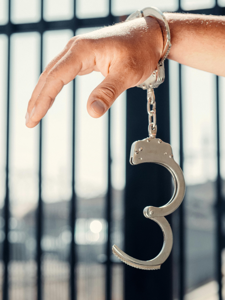 A man’s hand is in handcuffs.