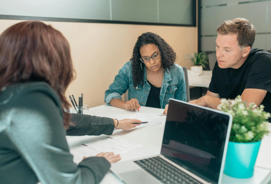 This image shows a lawyer discussing with a couple.