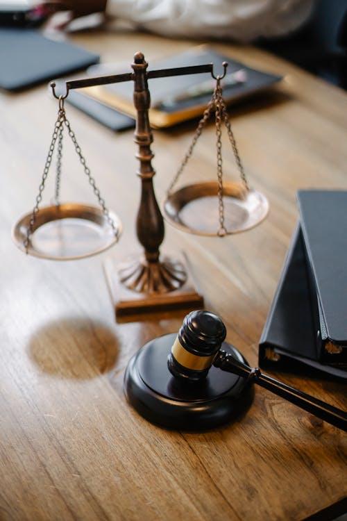 Brass justice scales and gavel on a wooden judge's desk representing the North Carolina pretrial release system