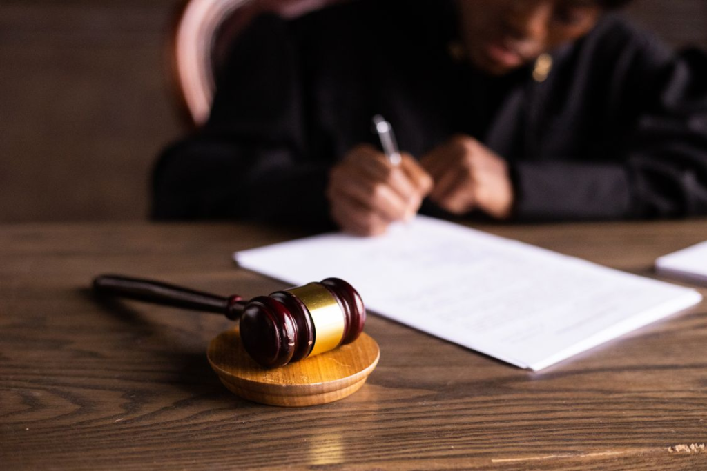 An image of a judge signing on bail papers