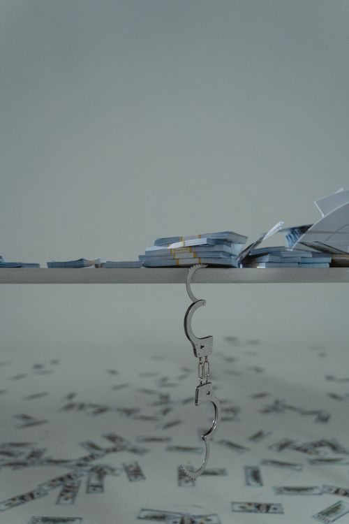 An image of handcuffs and cash on a table