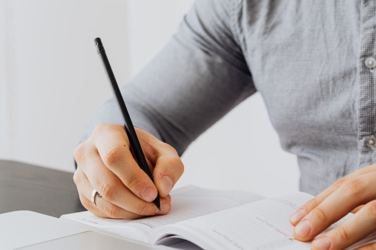 An image of a person writing something in a notebook