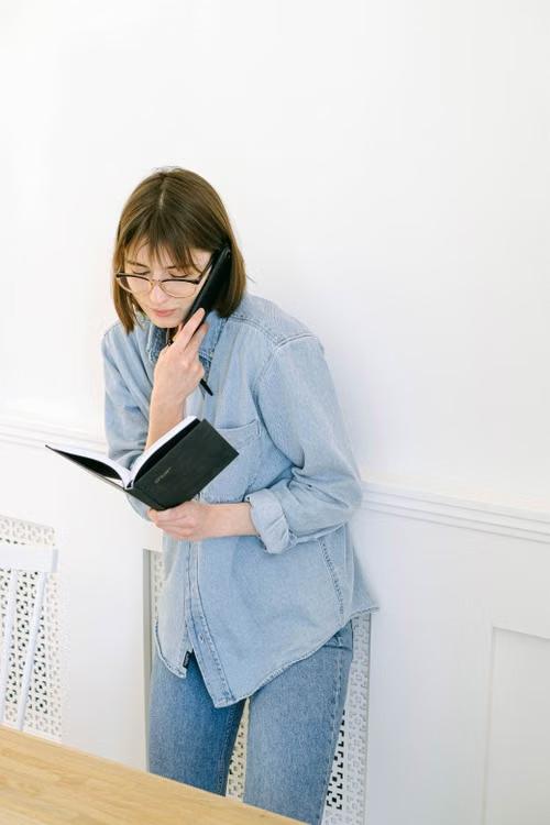 Woman holding a diary while talking on the phone