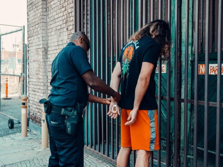 Police officer handcuffing a man during an arrest, representing the beginning of the bail process in North Carolina.