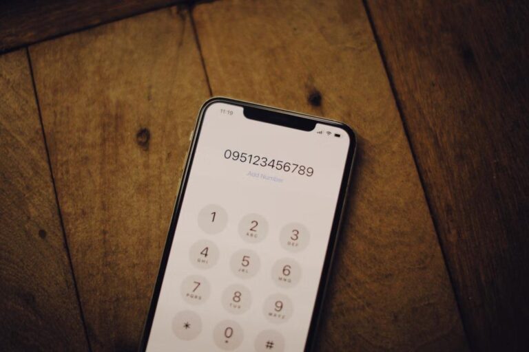 Mobile phone on a wooden surface representing the importance of keeping contact information current during the bail process.
